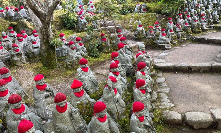 Centaines de petites statues avec des petits bonnets rouges à l'entrée du temple bouddhique Daishô-in